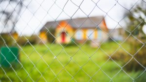 Temporary fencing installed around residential home for security during renovation.